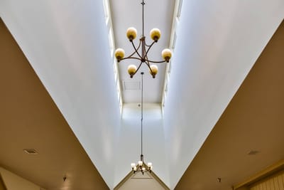 Interior view of a well-lit hallway with chandeliers