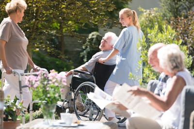 Residents enjoying time outdoors with staff assistance