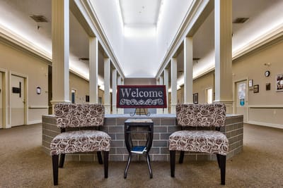 Welcome sign in a well-lit hallway with chairs