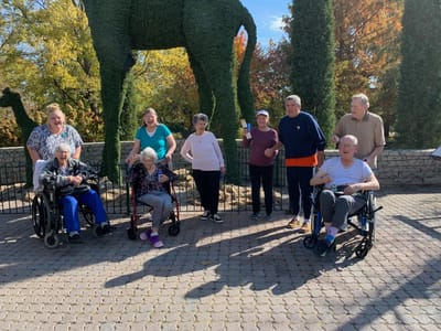 Residents posing together in an outdoor space with greenery