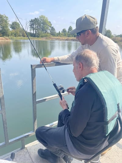 Two men fishing by a serene lake