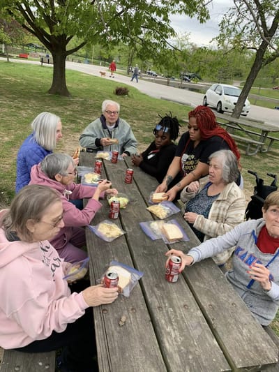 Residents enjoying lunch outdoors at a picnic table