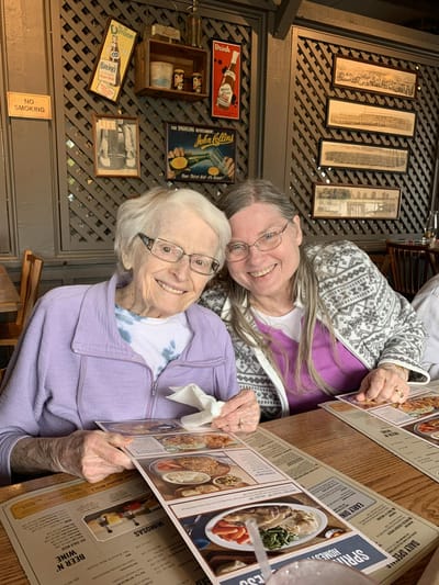 Two residents smiling together at a dining table