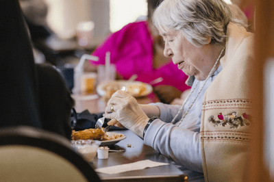 Resident enjoying a meal in the dining room