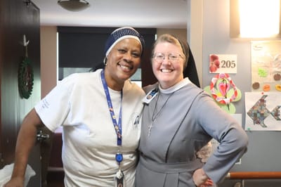 Two staff members smiling in a facility interior