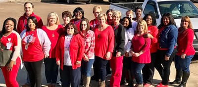 Staff members posing together outside the facility