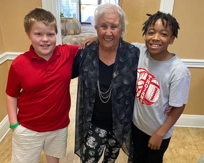 Residents smiling with children in a common area