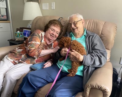 Residents enjoying time with a puppy in a common area