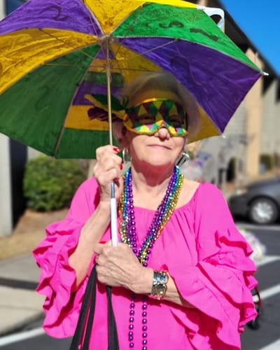 Resident participating in a celebration with a colorful umbrella