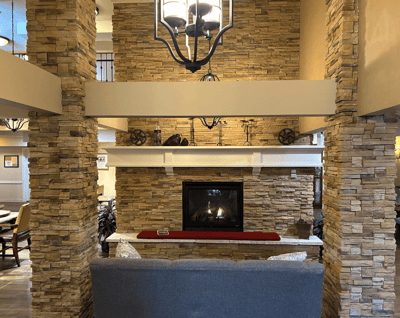 Cozy common area with a fireplace and stone wall