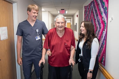 Staff assisting a resident in a hallway