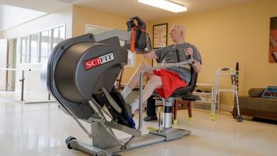 Elderly man exercising on a recumbent bike in a bright room