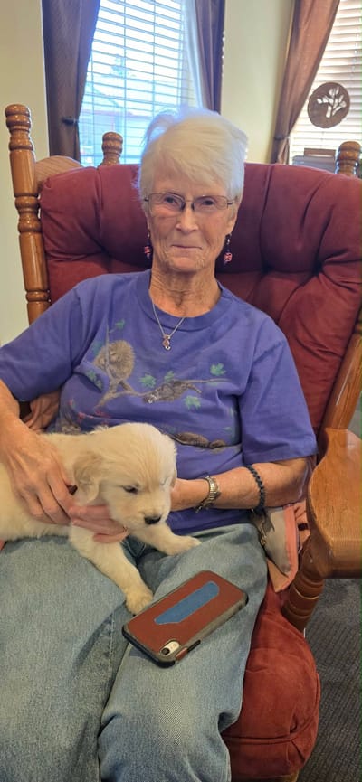 Resident holding a puppy in a cozy chair
