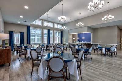 Bright dining room with elegant seating and chandeliers