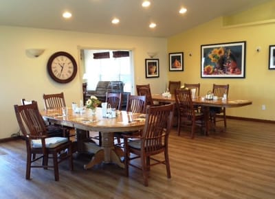 Dining area with wooden tables and chairs set for a meal