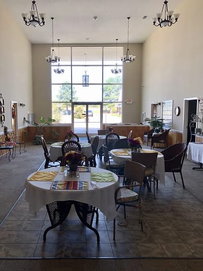Dining area set up for a meal with tables and chairs