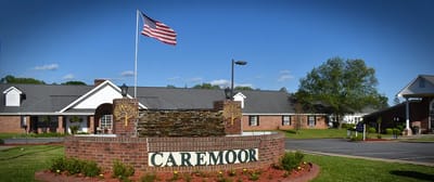 Exterior view of Caremoor Retirement Center with American flag