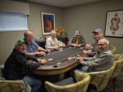 Residents enjoying a card game in a recreation room