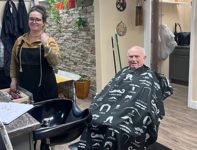 A resident getting a haircut with a stylist in a salon