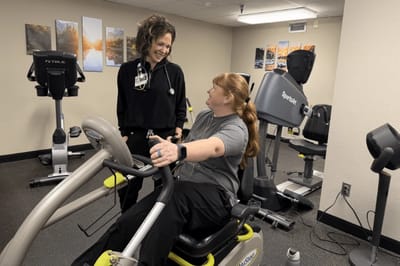 Staff assisting a resident in the fitness area