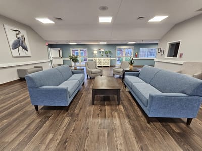 Cozy common area with blue couches and wooden table