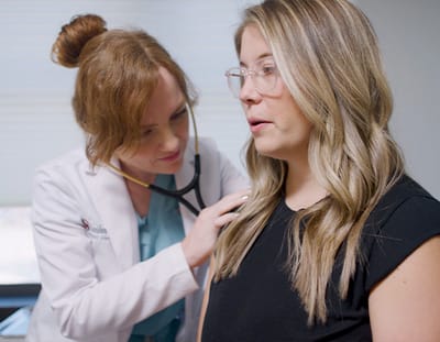 A nurse examining a female patient in a medical setting