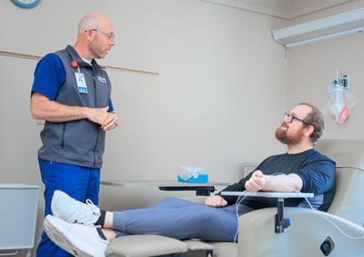 Healthcare staff assisting a resident in a treatment room
