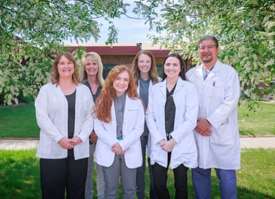 Staff members posing outdoors in front of the facility
