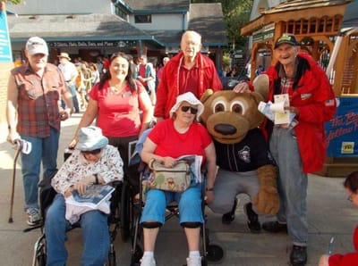 Residents and staff enjoying an outing with a mascot