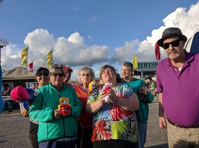 Residents holding stuffed animals at an outdoor event