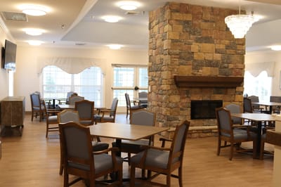 Interior dining area with stone fireplace and seating