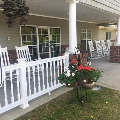 Outdoor rocking chairs with flower pot near entrance
