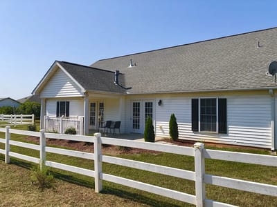 Exterior view of Caremoor Retirement Center with white fence