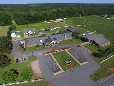 Aerial view of Caremoor Retirement Center with gardens and parking