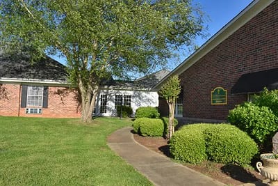 Exterior view of Caremoor Retirement Center with landscaping