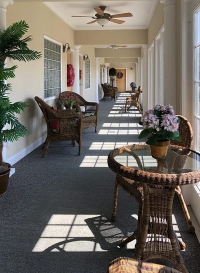 Brightly lit interior corridor with wicker furniture
