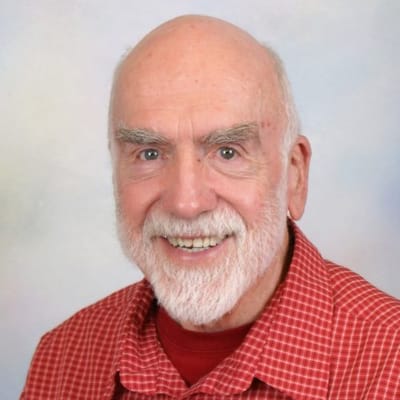 Senior man smiling in a red checkered shirt