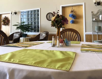 Interior dining area with table settings and flowers