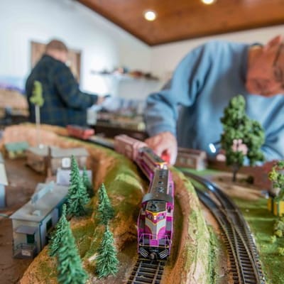 Residents enjoying a model train activity in a common area