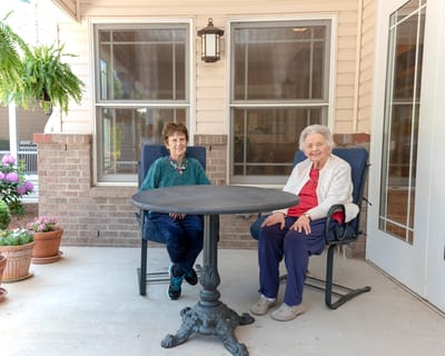 Two residents enjoying time on a patio