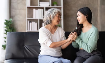 Two women engaged in a heartfelt conversation on a couch
