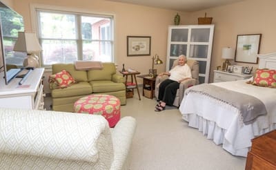 Resident in a cozy private room with comfortable furnishings