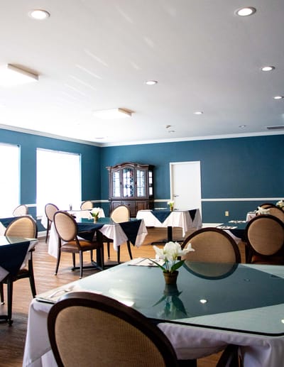 Bright dining room with tables and flowers