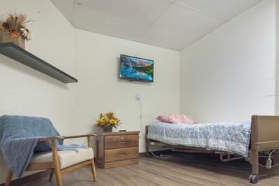 Cozy resident room with a bed and chair