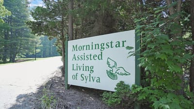Sign for Morningstar Assisted Living along a wooded path