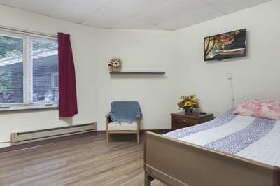 Cozy resident room with a bed and chair
