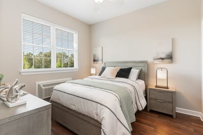 A well-decorated private resident room with a bed and furniture