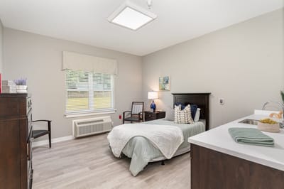A well-furnished private bedroom in a senior living facility