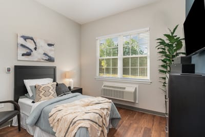 Brightly decorated resident room with a bed and window