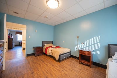 A private resident room with a bed and blue walls